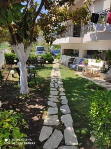 a stone path in front of a house with a tree at Rousetis in Aigio