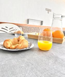 a table with a plate of croissants and orange juice at Imperial Villas I Casa Yei in Puerto del Carmen