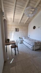 a bedroom with a bed and a table and a desk at פנינה בעתיקה in Safed