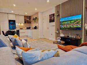 a living room with couches and a large screen tv at Wembley Cozy Cloud Waterfront Retreat with Parking near Wembley stadium in London