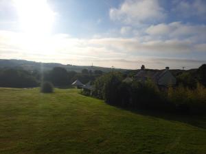 eine Wiese mit Häusern in der Ferne in der Unterkunft Bell Tent 2 in St Austell + 2 Fotos