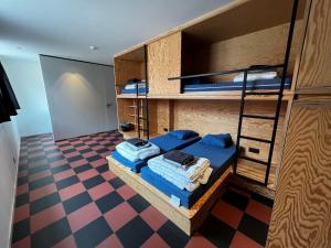 a room with bunk beds and a checkered floor at Horizon Hostel in Bredene