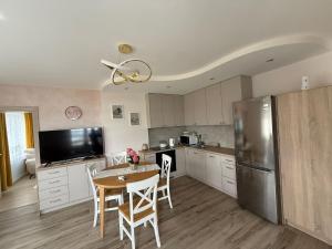 a kitchen with a table and a stainless steel refrigerator at Szept Jeziora in Czechowizna