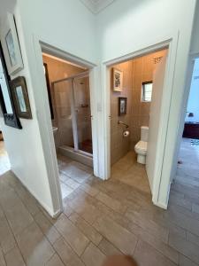 a bathroom with a shower and a toilet at Beachfront petfriendly cottage in Zinkwazi Beach +25 photos