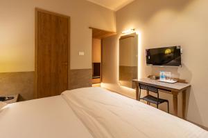 a hotel room with a bed and a desk with a television at Reay Road Residency Hotel in Mumbai