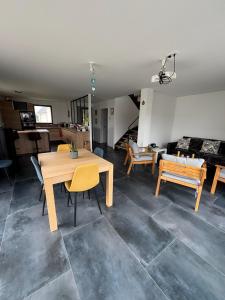 ein Wohnzimmer mit einem Holztisch und Stühlen in der Unterkunft A 8 mns des plages ! Maison moderne avec jardin et grande terrasse in Saint-Gildas-de-Rhuys