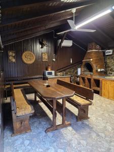 Un comedor con una mesa y un horno de pizza. en Cabana Burebista, en Costeşti