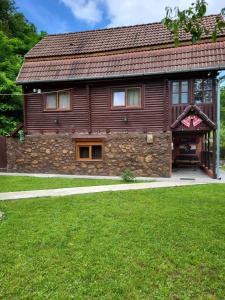 una gran casa de madera con una pared de piedra en Cabana Burebista, en Costeşti