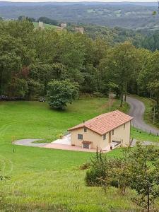 a small house in a field next to a road at Bienvenue chez nous in Cardaillac +14 photos