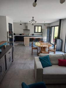 a living room and kitchen with a couch and a table at Bienvenue chez nous in Cardaillac