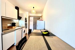 eine Küche mit einem Kühlschrank und einem schwarz-gelben Gegenstand auf dem Boden in der Unterkunft Refuge des Prés in Saint-Gervais-les-Bains