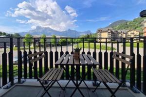 einen Tisch und zwei Stühle auf einem Balkon mit Bergblick in der Unterkunft Refuge des Prés in Saint-Gervais-les-Bains + 4 Fotos