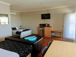 a hotel room with two beds and a couch at Ocean Drive Motel in Bunbury