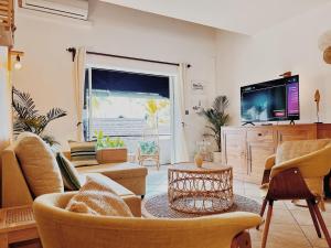 a living room with a couch and a tv at SEAS the DAY luxury seafront! in Grand Baie