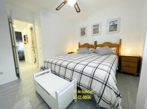 Un dormitorio con una cama con un edredón blanco y negro. en Hervas Centro Apartamento IDEAL FAMILIAS 6 adultos y 2 niños-, en Hervás
