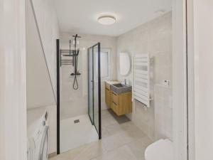a white bathroom with a sink and a shower at 300m plage - maison pour 7 avec grande terrasse in Penmarcʼh +16 photos