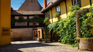 an alley in an old building with ivy at L'Abbaye d'Alspach in Kientzheim