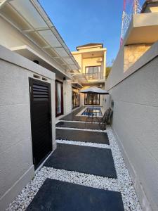 a walkway leading to a house with a door at Villa Cendana By RMBS in Nusa Dua