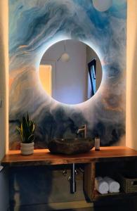 a bathroom with a sink and a large mirror at Celest Boutique Urban Hideaway in Braşov
