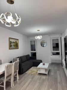 a living room with a couch and a table at Bratti's Apartment 2 Near Tirana Center And Mother Teresa International Airport in Laknas