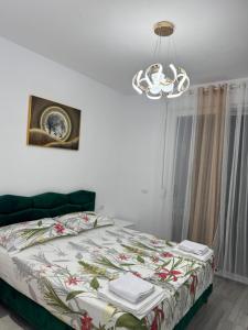 a bedroom with a bed and a chandelier at Bratti's Apartment 2 Near Tirana Center And Mother Teresa International Airport in Laknas