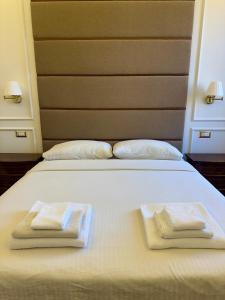 - un lit blanc avec 2 serviettes pliées dans l'établissement Dandy Elegance Loft, à Rome