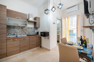 a kitchen with a table with chairs and a sink at Dimora Don Gabriele in Mola di Bari