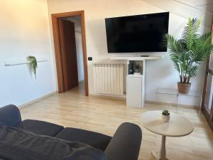 a living room with a blue couch and a tv at Modern Apartment 5 mins Rho Fiera Milano in Rho