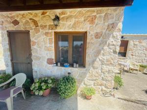 マクリにあるCountry House at Alexandroupoli (Dikella)の窓と椅子と植物のある石造りの家 +11枚の写真