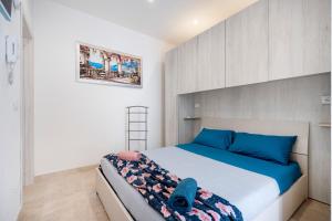 a small bedroom with a bed with blue pillows at Dimora Don Gabriele in Mola di Bari