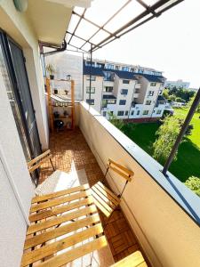 a balcony with two wooden benches on a balcony at Apartment Loft Fifteen in Dunajská Streda