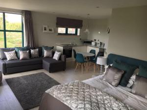 a living room with a couch and a table and a kitchen at Penrith Retreats in Penrith