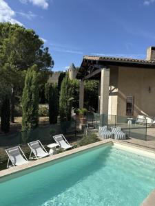 a swimming pool with lounge chairs next to a house at Panorama by maison bacou in Carcassonne