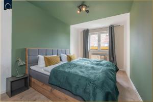 a bedroom with a bed with a green blanket at Dock23 in Kolpinsee
