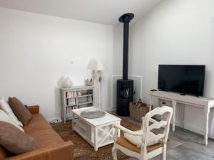 a living room with a couch and a fireplace at Gite La Grange Hulotte in Chaillé-les-Marais