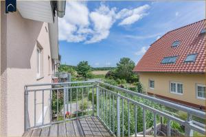 a balcony with a wooden walkway next to a building at Dock23 in Kolpinsee