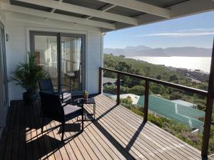 a balcony with a chair and a view of the water at Oceans Drift Guest House & Self Catering in Simonʼs Town