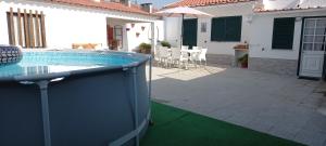 a house with a swimming pool and a patio at Murta's Home in Cadaval