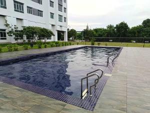 a swimming pool in front of a building at Kemaman KondoRoomStay SwimPool,Gym, Chukai Trg Private in Cukai