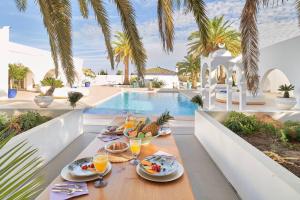 a table with food and drinks next to a swimming pool at Riad Salt Pool Bliss Apartamentos in Torremolinos