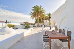 a patio with a wooden table and chairs on a building at Riad Salt Pool Bliss Apartamentos in Torremolinos
