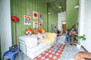 a living room with a white couch and green walls at Baan Lek Tee 6 - Chinatown near Yaowarat and MRT in Bangkok