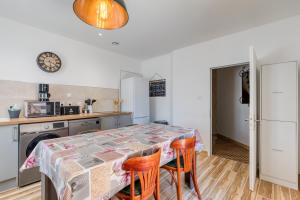 a kitchen with a table and some chairs at Gîte A La Bonne Franck'ette in Aspiran