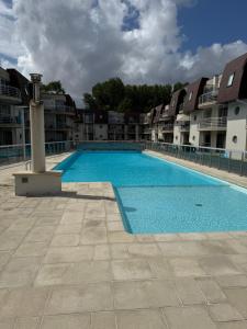 a large swimming pool in front of some apartment buildings at Blutsyde Cannes luxury appartment in Bredene