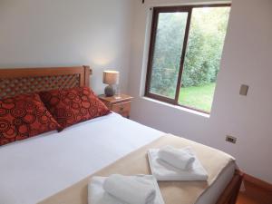 a bedroom with a bed with two towels on it at Casona el Sauce in Curicó