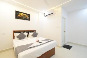 a bedroom with a bed in a white room at Sri Laveeza Hotels in Hyderabad