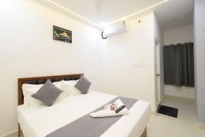 a bedroom with a white bed with a pair of shoes on it at Sri Laveeza Hotels in Hyderabad