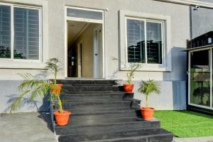 a house with three potted plants on the stairs at Sri Laveeza Hotels in Hyderabad