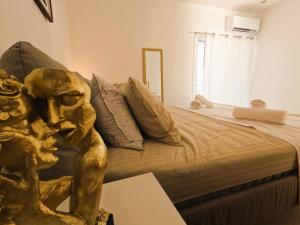 una camera da letto con un letto con una statua sopra di Stylish Rooftop Retreat with Hot Tub with Loutraki Beach a Loutraki