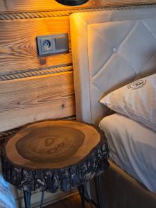 a room with a bed with a wooden table next to a bed gmaxwell at Noclegi Panorama - Domek RUSTIC in Ustrzyki Dolne